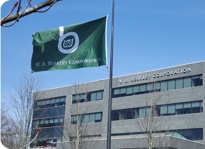 A green W.R. Berkley flag waves in front of the W.R. Berkley Corporation Headquarters